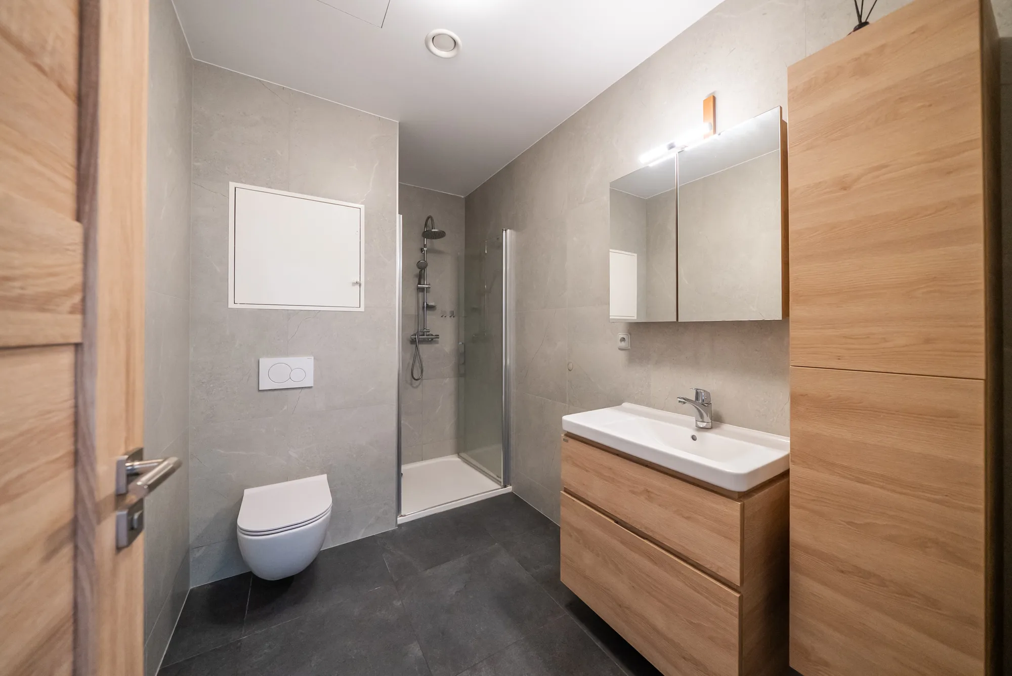 Koupelna s WC, umyvadlem se skříňkou a zrcadlem